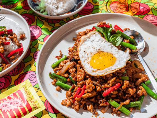 Krapow dish served on a plate with a fried egg on top. The meal starter packet lies next to the plate. 