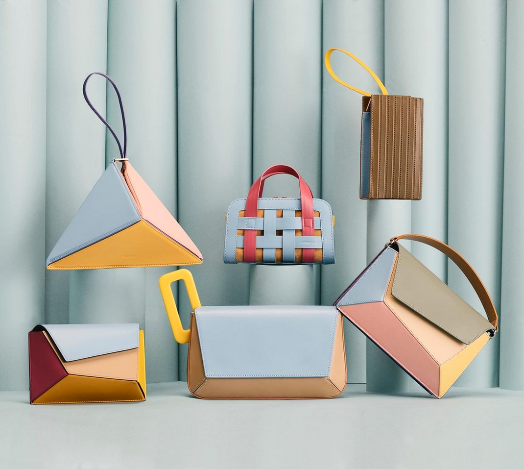A colorful collection of handbags against a blue background.