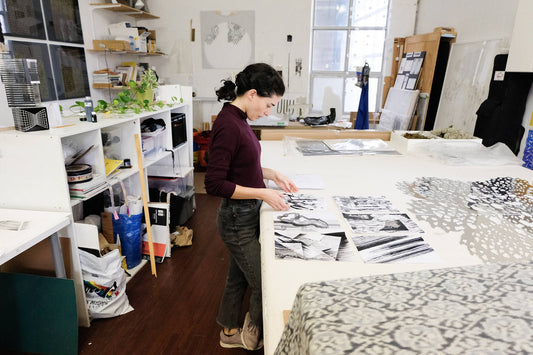 Sofia standing at her workbench in her studio. 